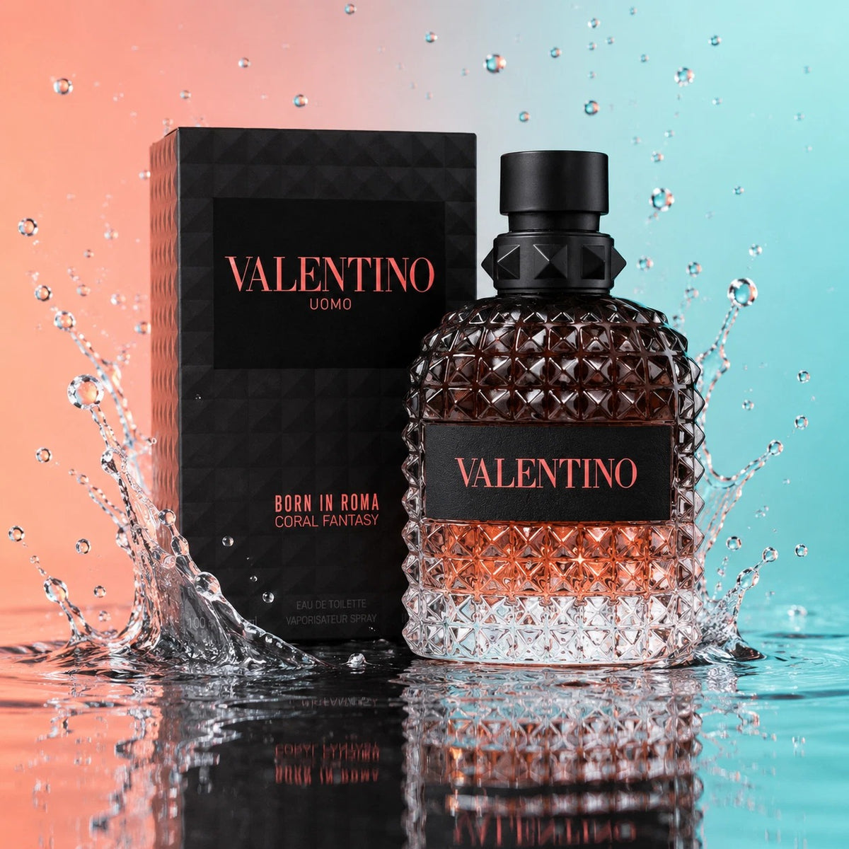 Valentino Uomo Born in Roma Coral Fantasy Eau de Toilette bottle and packaging box, styled with water splashes on a reflective surface against a split orange and blue background.